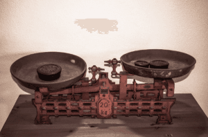 De weegschaal staat voor het meten van de balans tussen ruimte en kaders, geven en nemen in de organisatiedynamiek